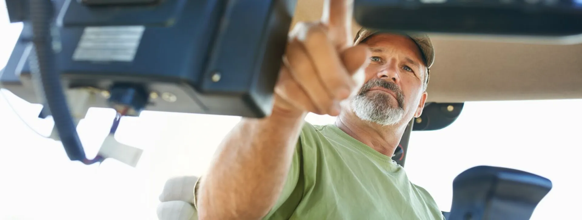 a farmer working inside the cab of a modern tractor 